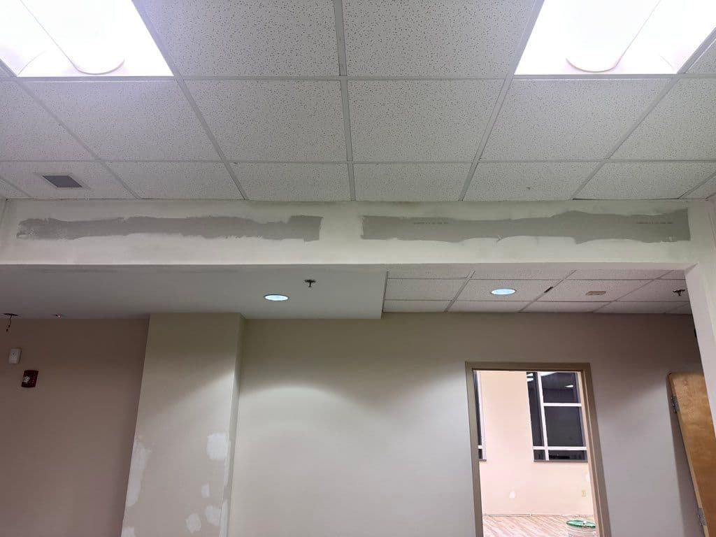 Drywall repair patched and mudded along interior commercial ceiling beam