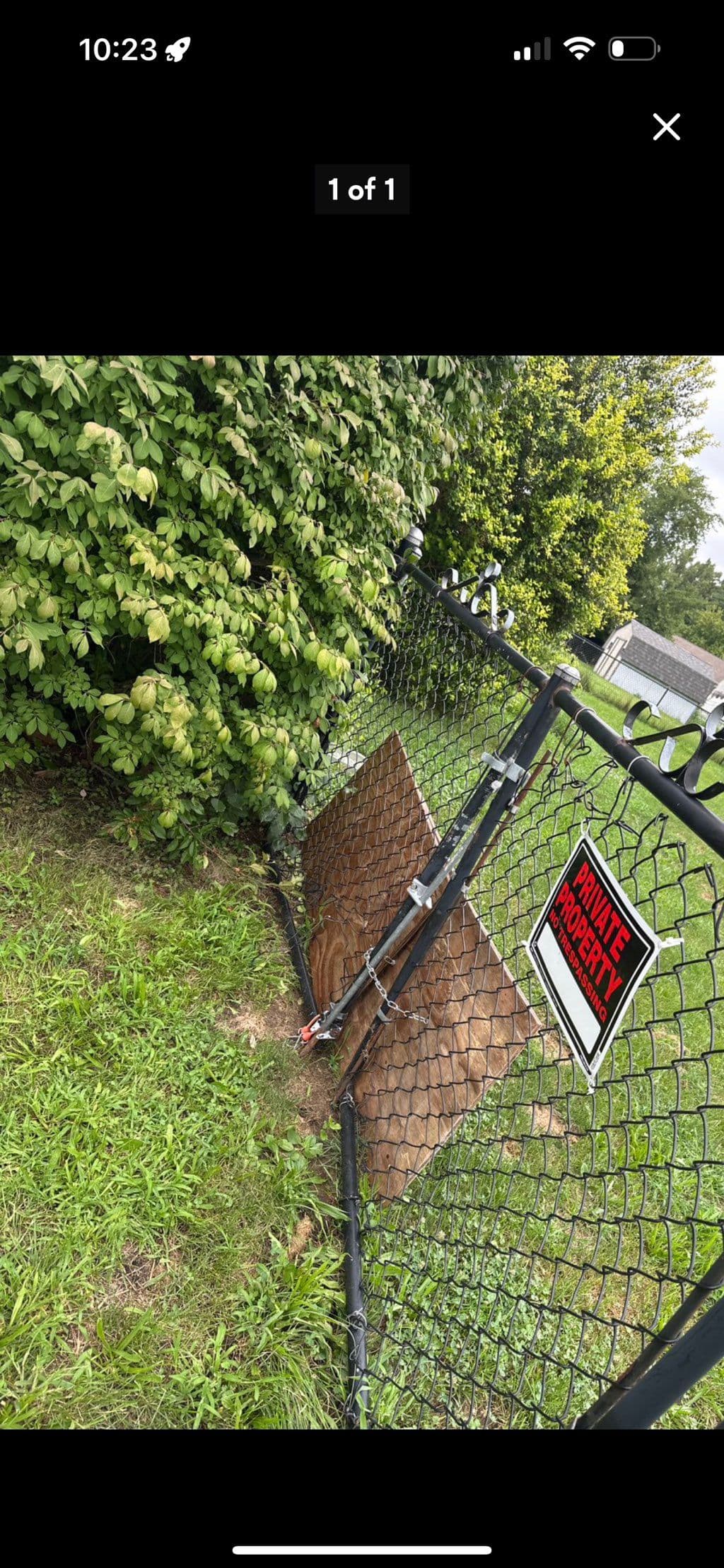 Black chain link fence gate with private property sign and chain lock