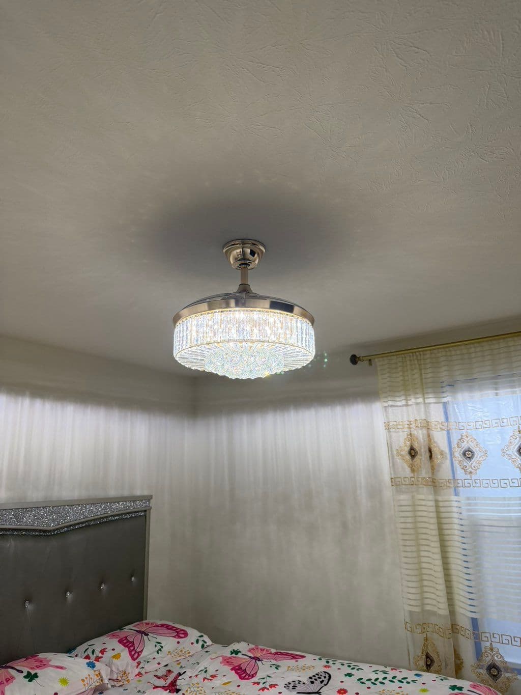 Crystal LED ceiling fan light fixture installed in bedroom